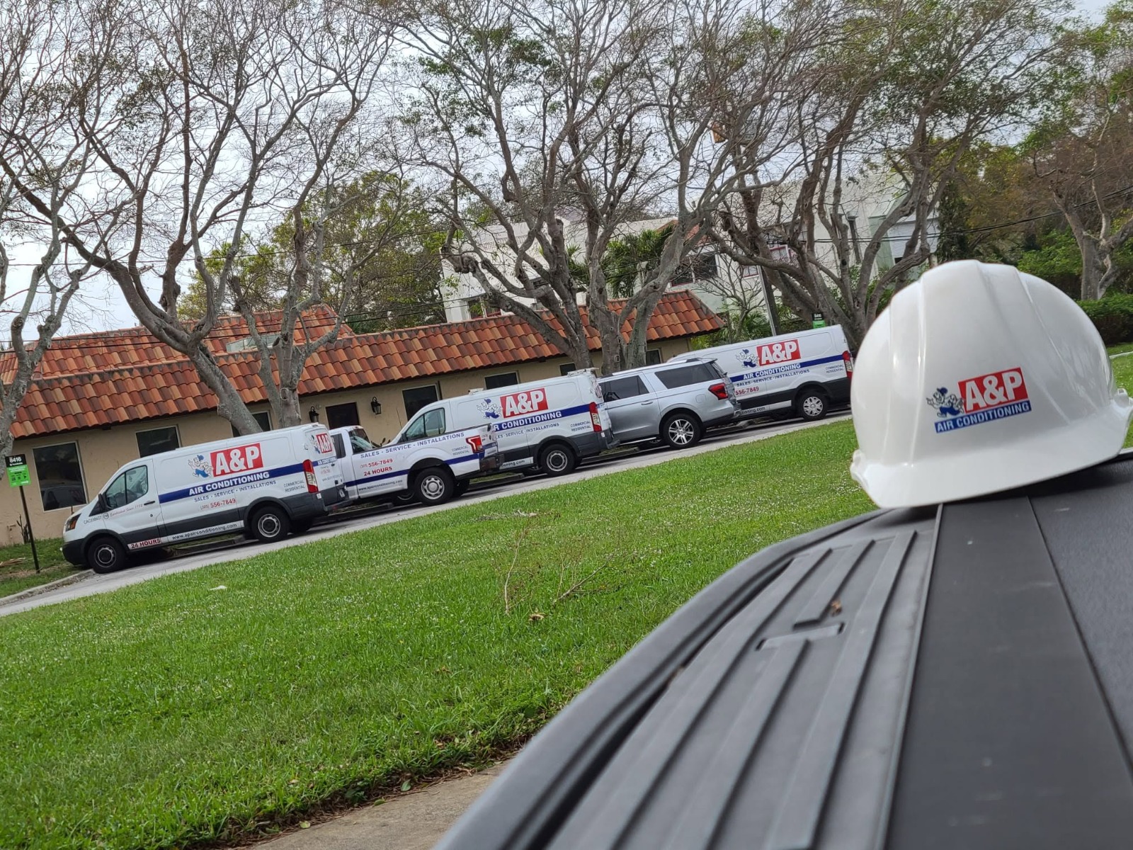 A&P Air Conditioning fleet vans lined up on a job